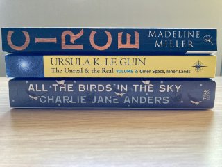 Three book spines: Circe by Madeline Miller, The Unreal And The Real by Ursula K. Le Guin, and All The Birds In The Sky by Charlie Jane Anders.