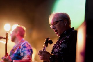 A profile shot of me on stage with my mandolin singing my heart out.