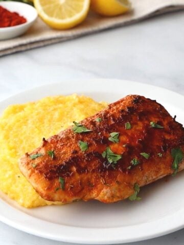 Blackened Mahi Mahi on plate served next to cheesy grits.