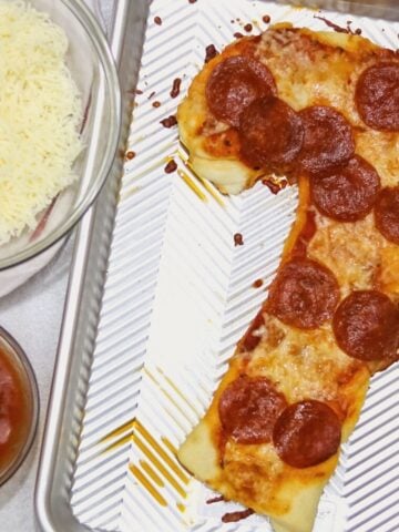 Candy Cane Shaped Pepperoni Pizza on baking sheet.