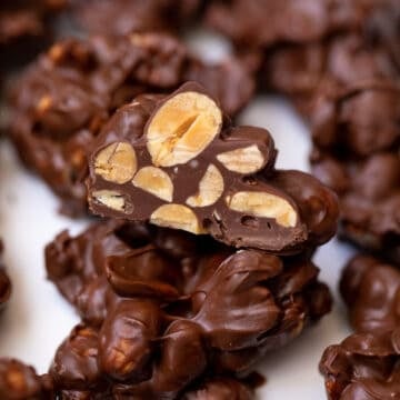 Chocolate covered nut cluster cut open to reveal peanuts.