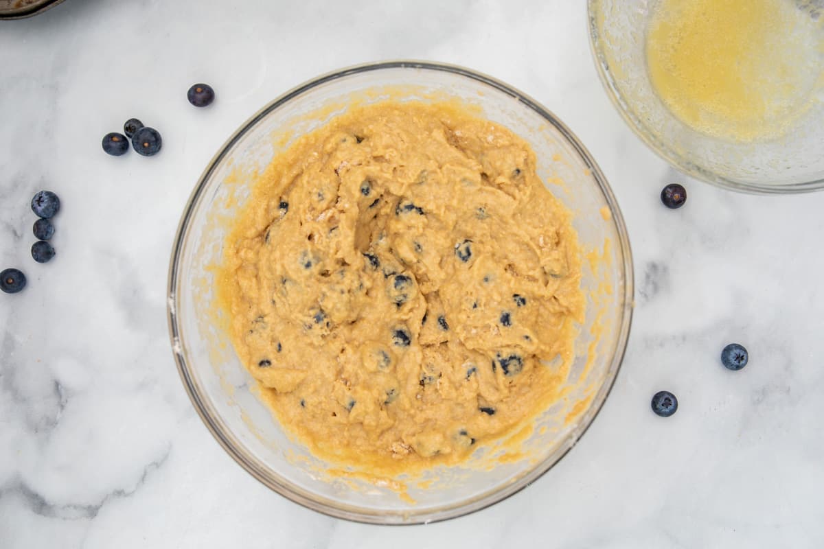 Blueberry Muffin batter mixed in clear mixing bowl. 