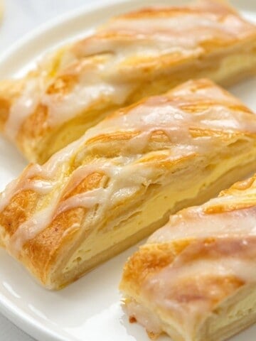 3 slices of cream cheese danish on white plate.