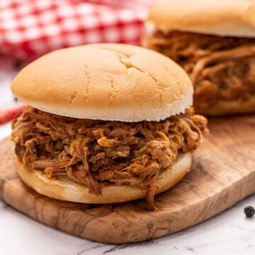 Pulled Pork on bun on cutting board.