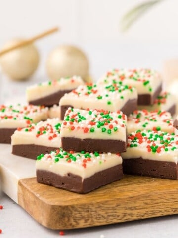 Layered fudge with Christmas sprinkles on cutting board.