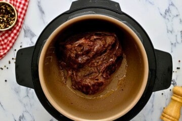 Seasoned chuck roast after being seared inside inner pot.