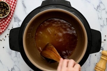 Wooden spatula scraping bottom of inner pot.