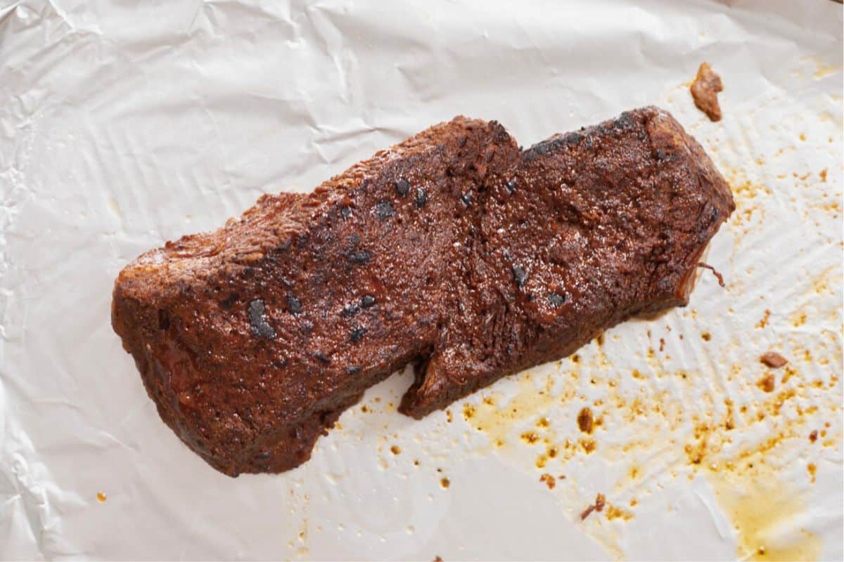 Broiled Instant Pot Brisket on sheet pan lined with foil.