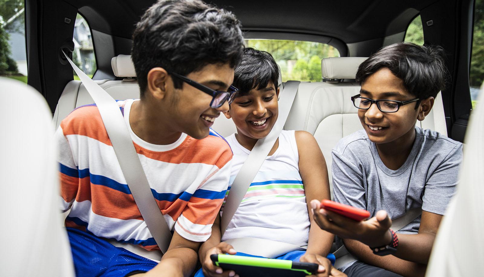 three boys in backseat of car