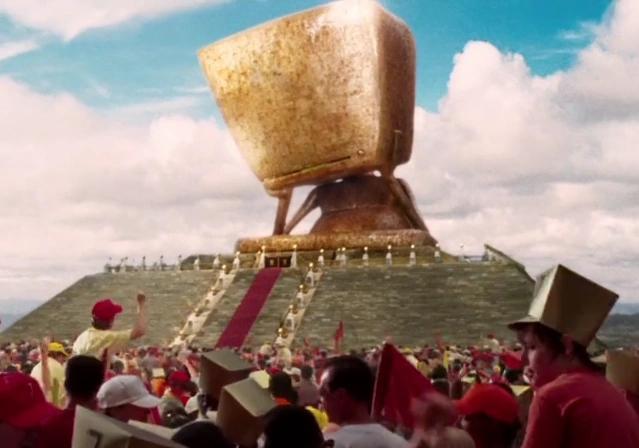 The computer “Deep Thought”, as depicted in the movie version of Hitchhiker’s Guide to the Galaxy.

An enormous golden figure sits atop a ziggurat, as a crowd of people eagerly await the answer to life, the universe, and everything.