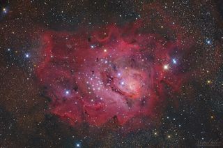 This image shows a wide-field view of the Lagoon Nebula, captured from the Cumeada Observatory, headquarters of the Dark Sky Alqueva Reserve in Portugal. Also known as M8, the Lagoon Nebula is a magnificent colorful complex of hot gas and dark nebulosity located in the Sagittarius constellation.