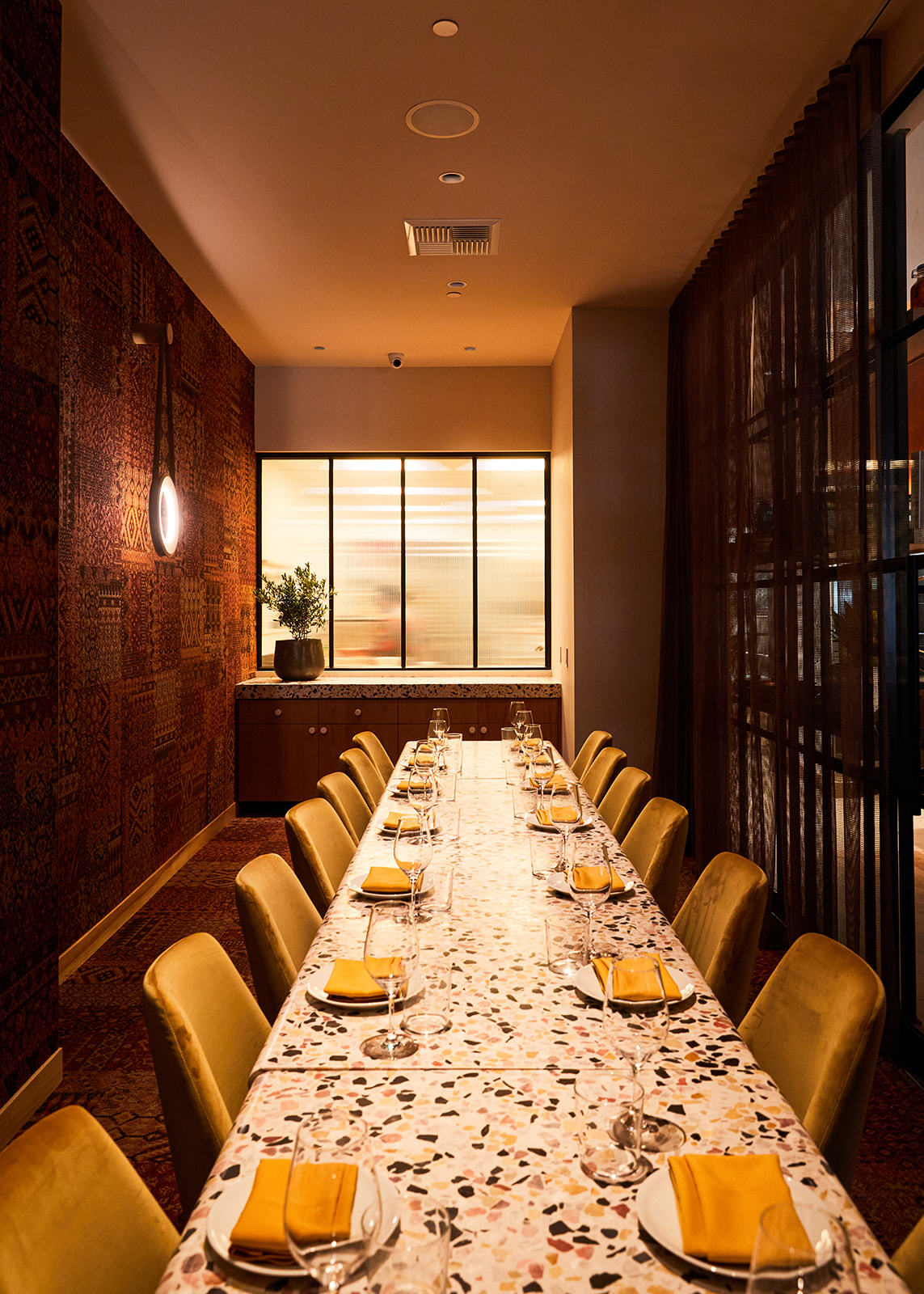 Interior view of a dimly lit restaurant private dining room with a festive marbled table.