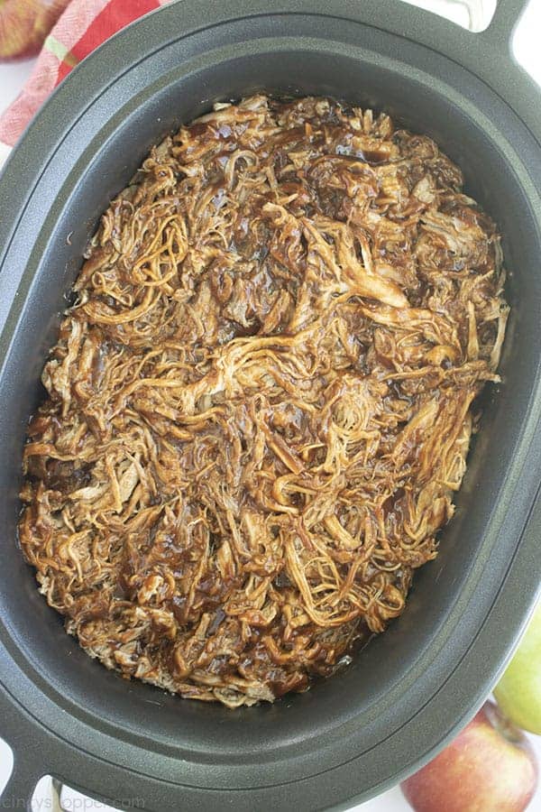 Overhead shot of Apple Cider Pulled Pork in the a black oval Slow Cooker