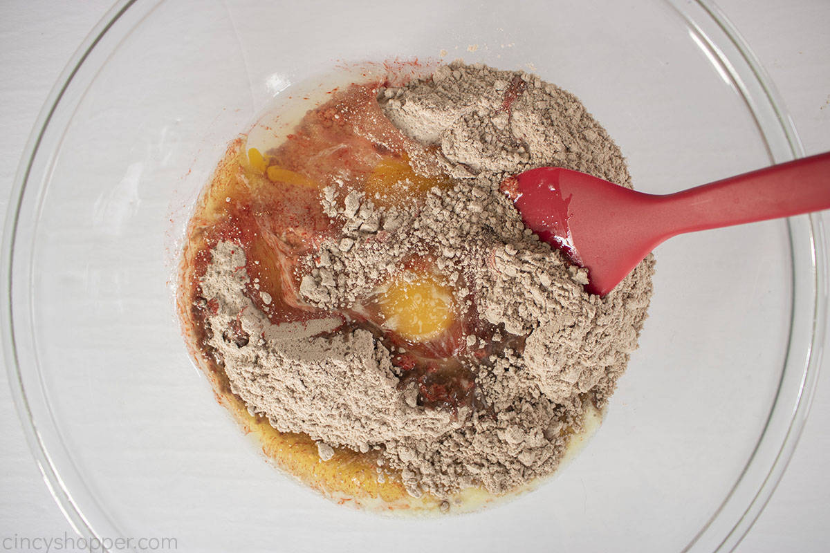 Red velvet cake mix ingredients for cookies in a mixing bowl.