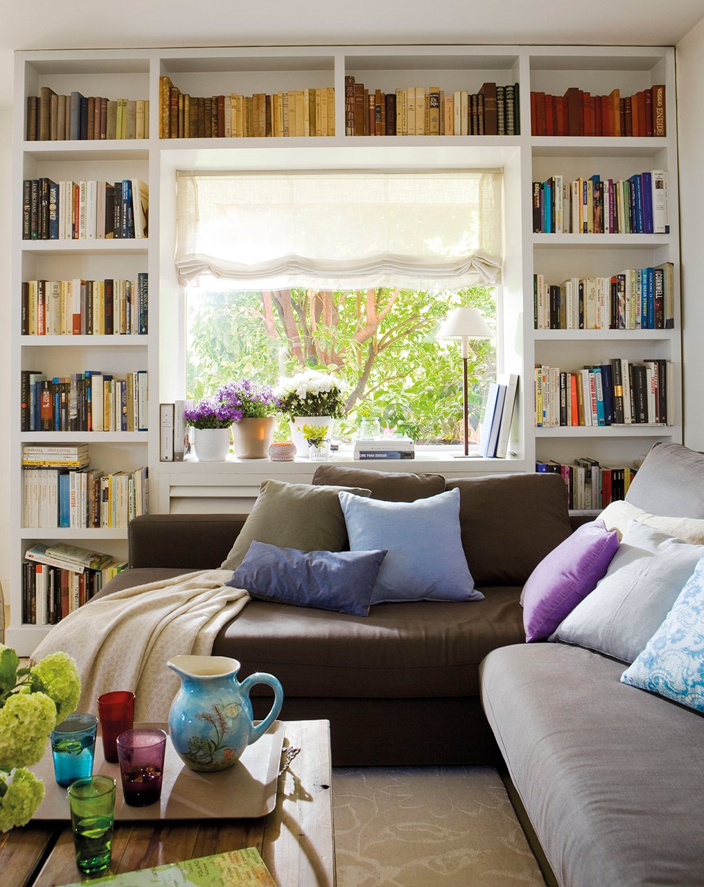 Salón con librería a medida alrededor de la ventana. 