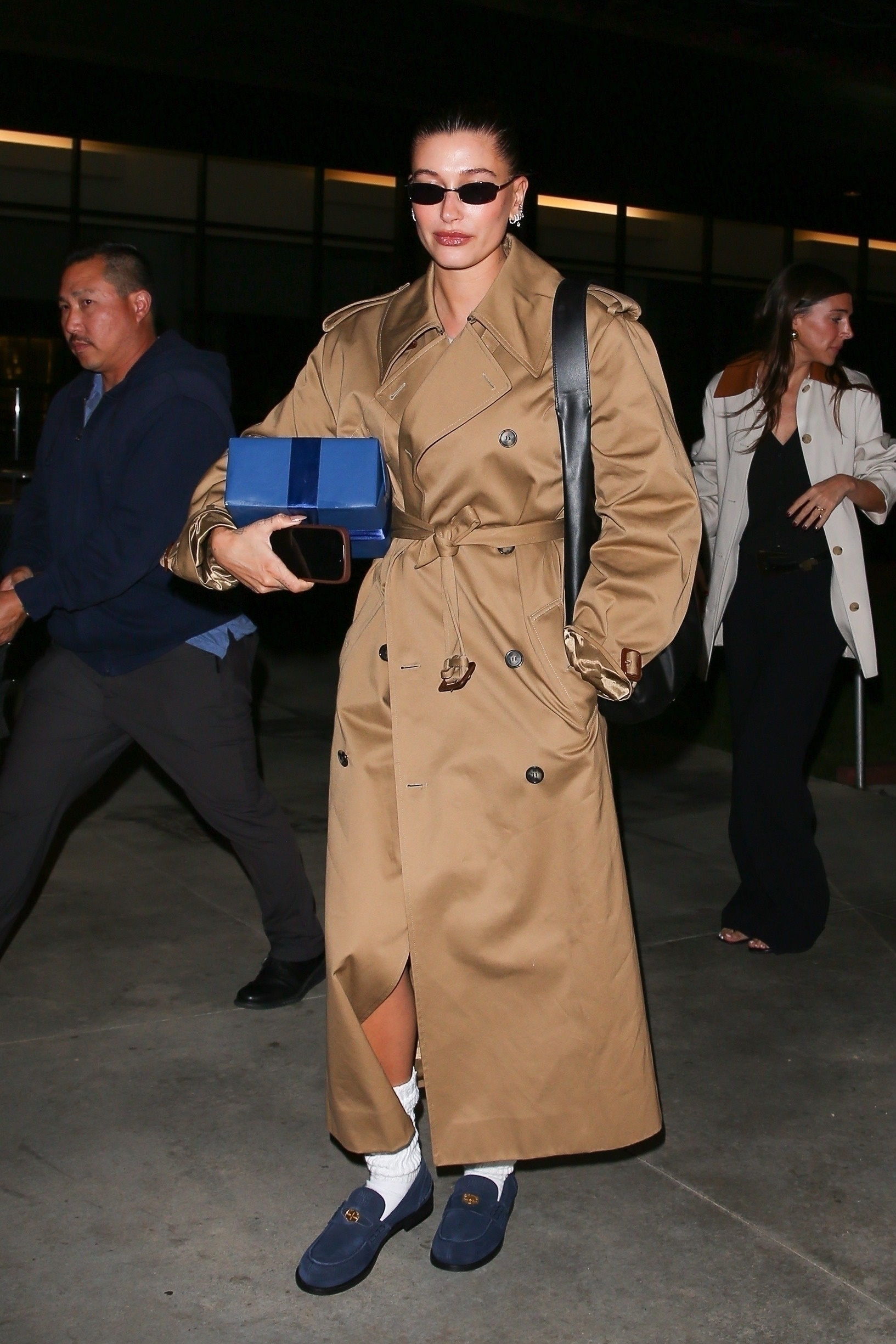 Trench season has officially landed, and Hailey Bieber is setting the standard for chic transitional outwear. Stepping out in Los Angeles, Bieber opted for a classic double-breasted belted trench from Saint Laurent paired with the Maison’s Le 5 À 7 hobo-style bag. Embracing the burgeoning corpcore trends, Bieber tied the look together with Miu Miu’s blue suede penny loafers and a chunky white sock—trés chic! Courtesy of Saint Laurent