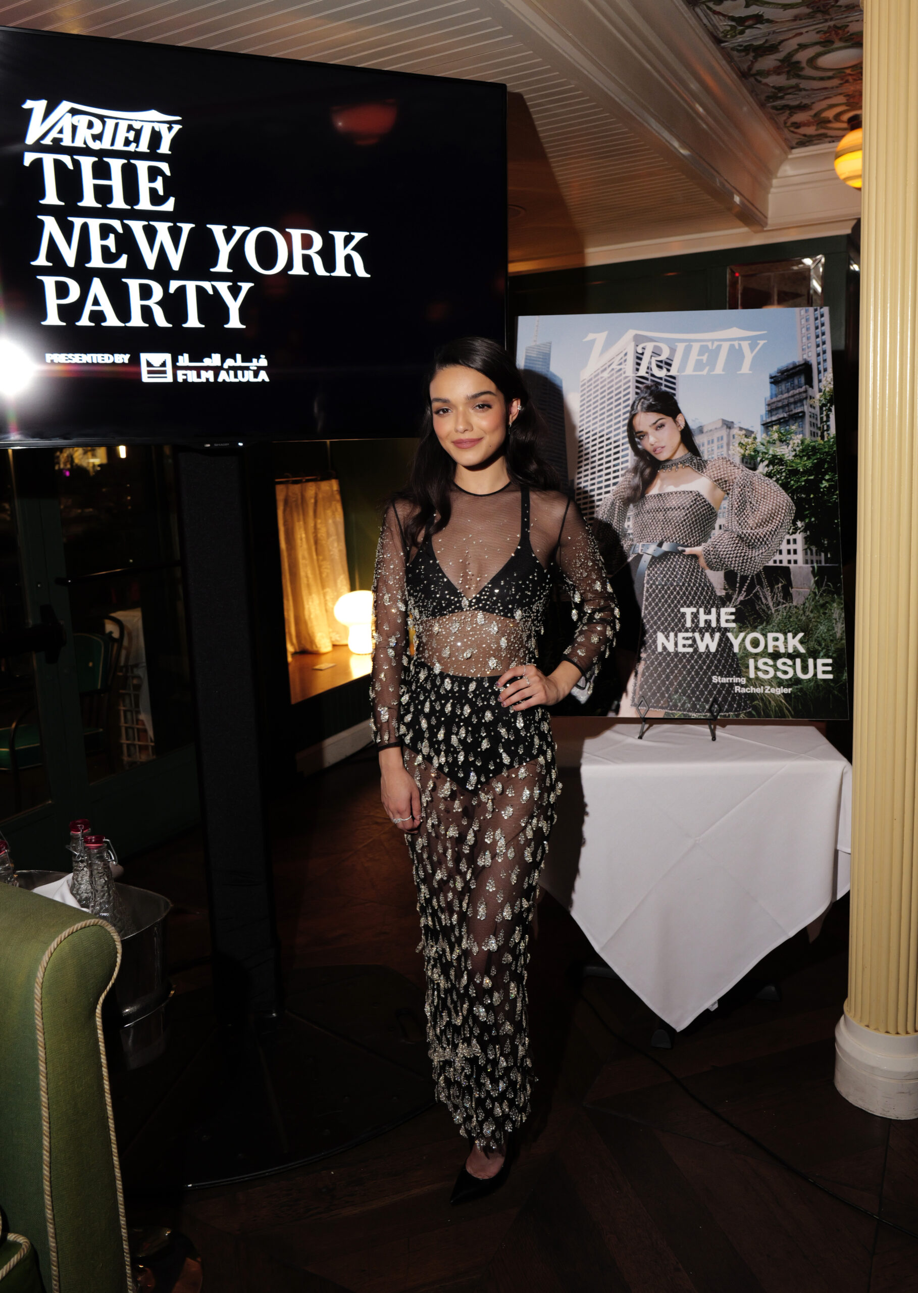 In honor of her new magazine cover for Variety’s New York Issue, Rachel Zegler attended a glamorous fête wearing a sheer embellished Dior dress. The star of the newly adapted Romeo + Juliet on Broadway paired the long frock with black undergarments that peek through the dark mesh and intricate sequining detailing. Simplistic silver accessories tie Zegler’s look together, allowing the dress to be the main event.  Courtesy of Dior