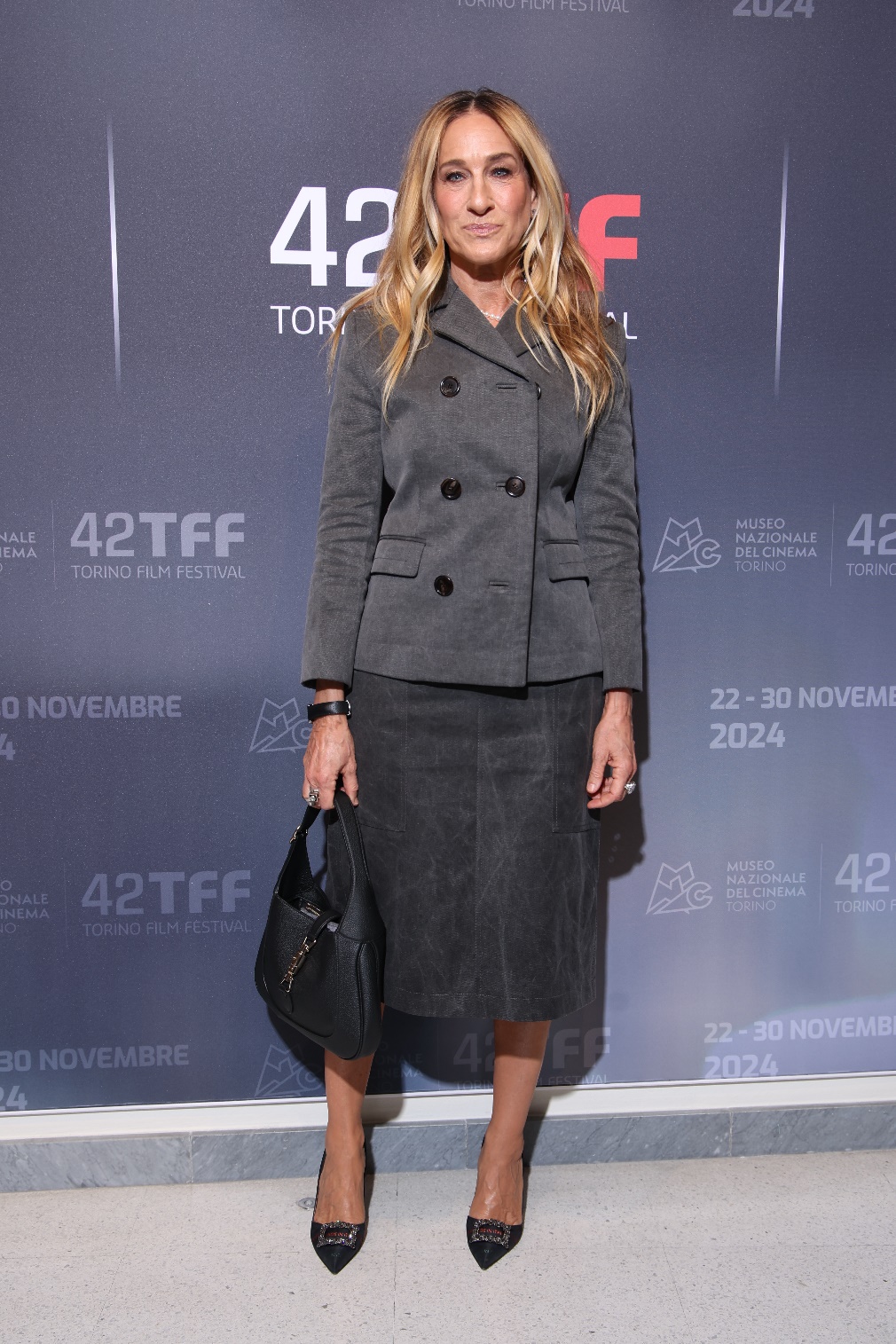 Sarah Jessica Parker attended this year’s 42nd Torino Film Festival 2024 in Turin, Italy this weekend looking sharp, smart, and sensible in Gucci. On top, she wore the structured Cruise 2025 cotton canvas jacket which was paired with its coordinating knee-length skirt in delavé dark grey. She accessorized the look with a Gucci Jackie bag in black leather and a simple pair of black pointed-toe heels.   Courtesy of Gucci