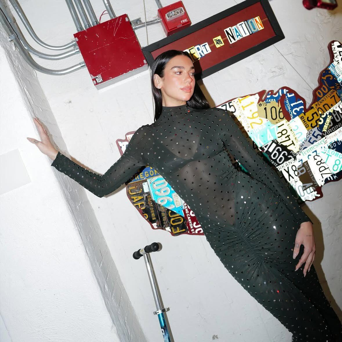 For her appearance on The Late Show with Stephen Colbert, Dua Lipa wore a show-stopping Alaïa dress from the Archetypes Winter-Spring 2025 collection by Pieter Mulier. Ahead of her primetime live performance from the Royal Albert Hall airing on December 15, the popstar stunned in a mock turtleneck sheer fitted dress with ruching at the hips and embellished with strass. Lipa kept her styling minimal with silver stud earrings and a single ring, wearing her shiny straight hair down with a middle part for a memorably chic refined statement look.  Courtesy of Alaïa