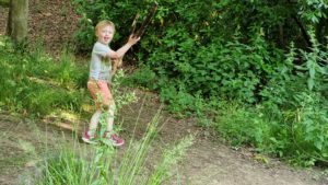 Kid carrying huge stick.