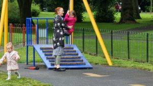 Sarah helps a child on a zipline.