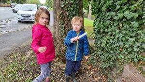 Two children hold a geocache.