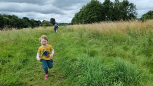 A boy runs away from two adults.