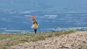 Steve Taylor wearing a bathtub and climbing Pendle Hill.