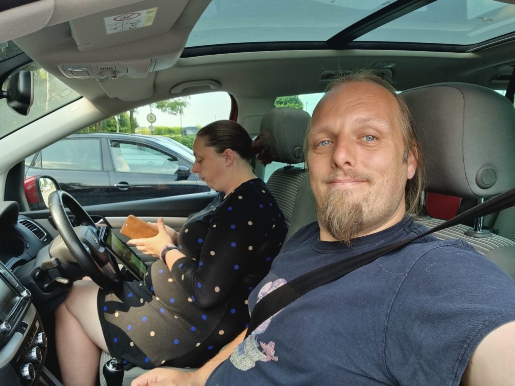 Ruth and Dan in a car, in a car park.