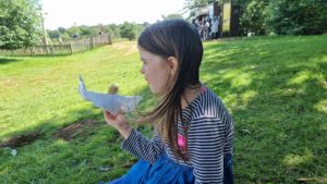 Girl eats half a sausage roll.