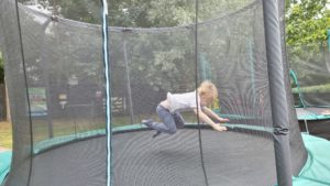 A boy dives onto a trampoline.