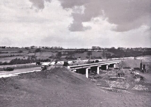 Monochome photograph showing construction of bridge support pillars.