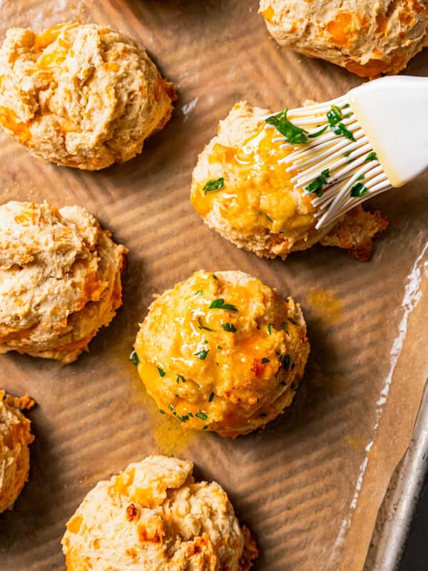 Brushing biscuits with garlic butter.