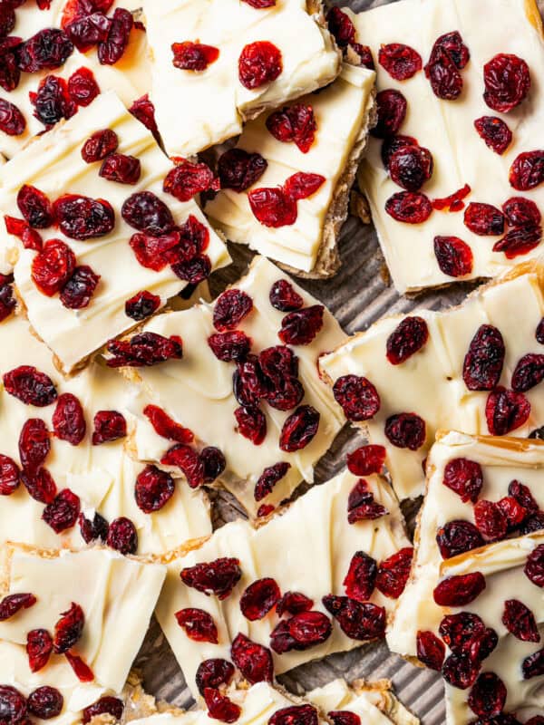 Up close image of Christmas crack topped with dried cranberries and broken into pieces.