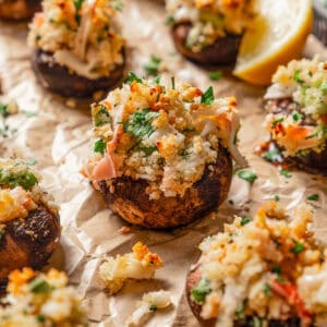 Stuffed mushrooms on a parchment-lined baking sheet.