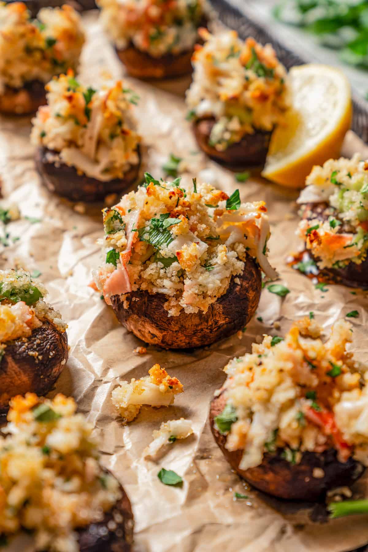 Stuffed mushrooms on a parchment-lined baking sheet.