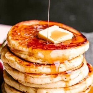 Pouring syrup over pancakes.