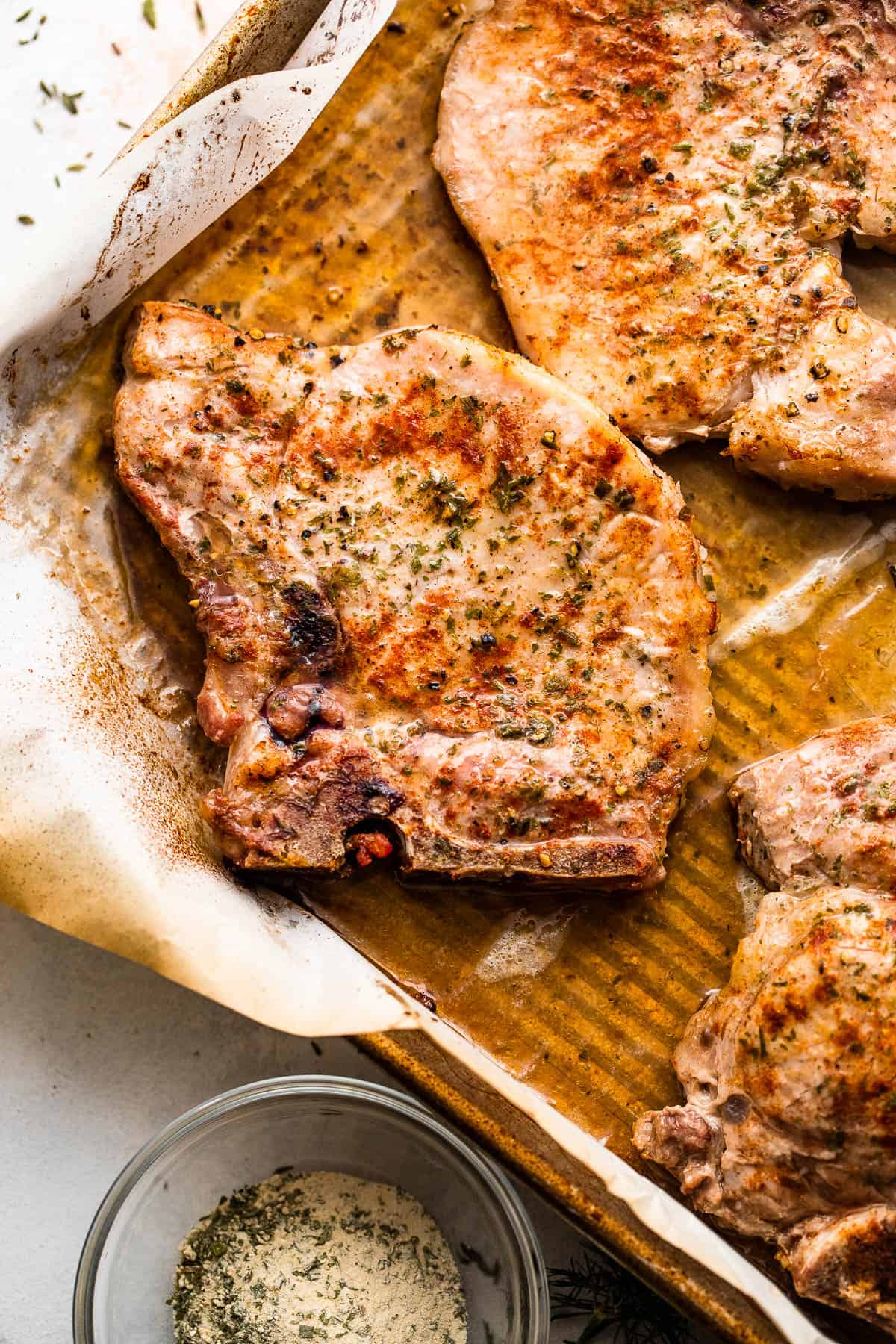 Cooked pork chops on a baking sheet.