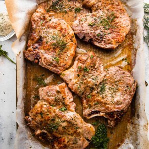 overhead shot of four baked pork chops on a baking sheet