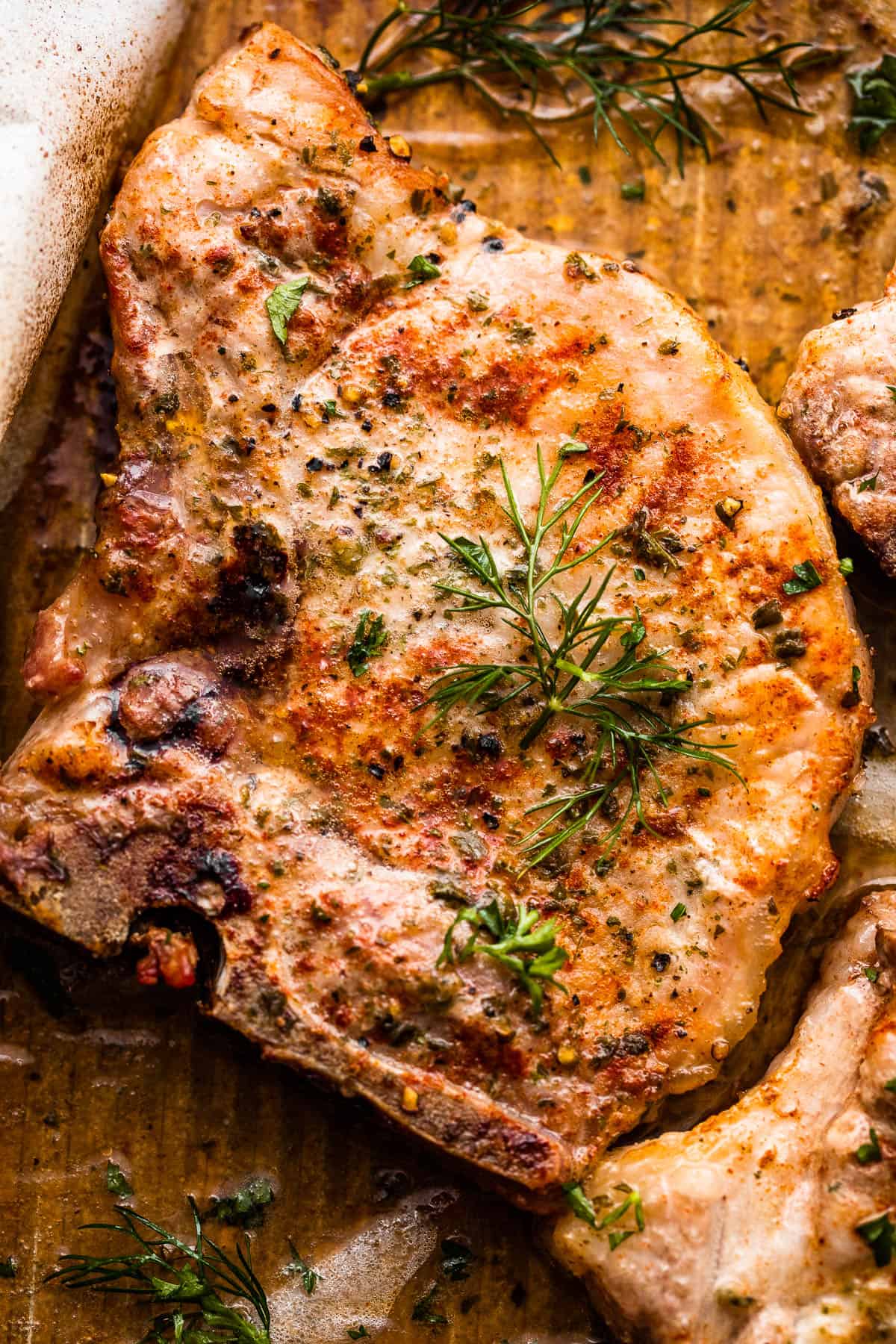 Close-up photo of one pork chop seasoned with ranch seasoning mix.