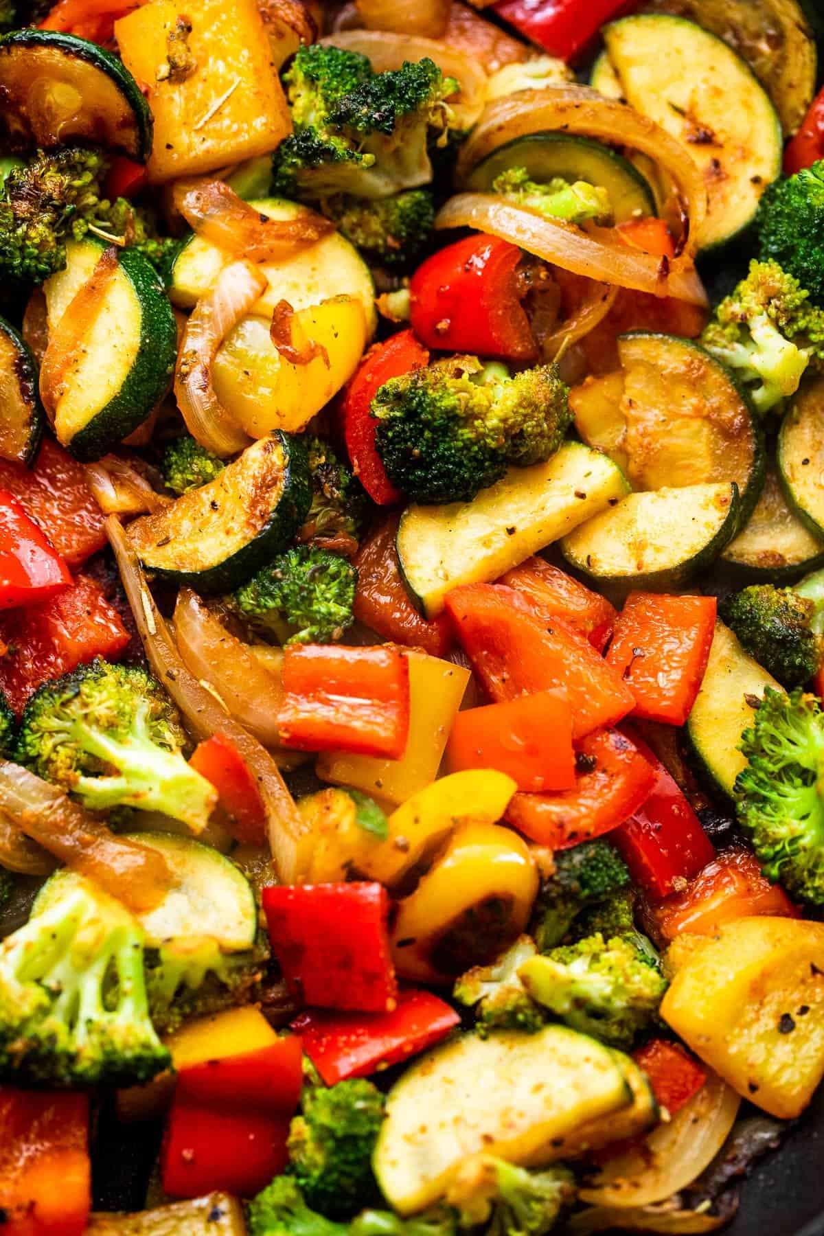 up close shot of broccoli florets, cut up bell peppers, and zucchini halves