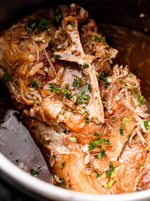 close up shot of a cooked pork shoulder garnished with parsley.