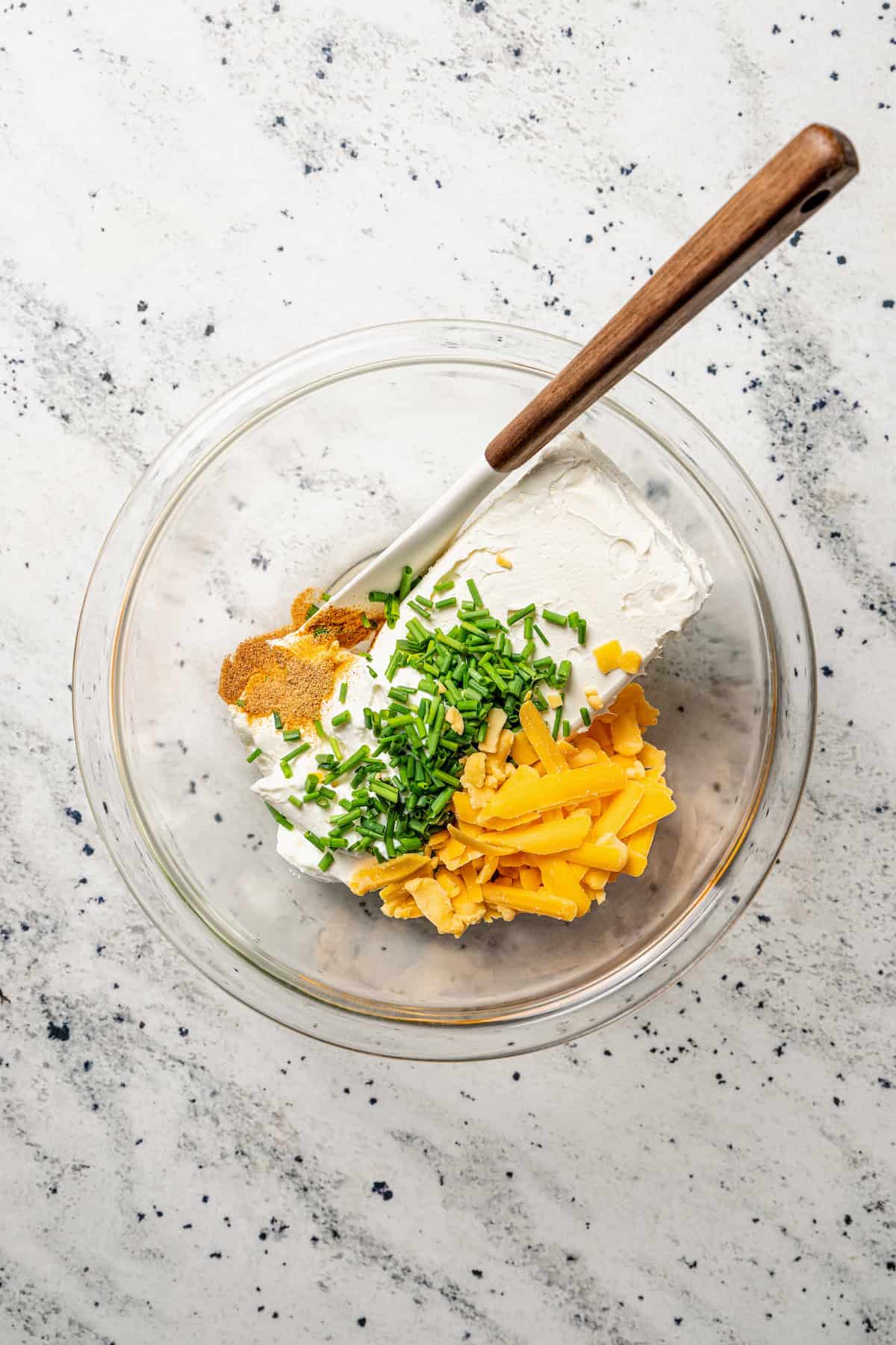 Cream cheese filling ingredients combined in a glass bowl.