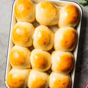 Freshly baked dinner rolls on a baking sheet.