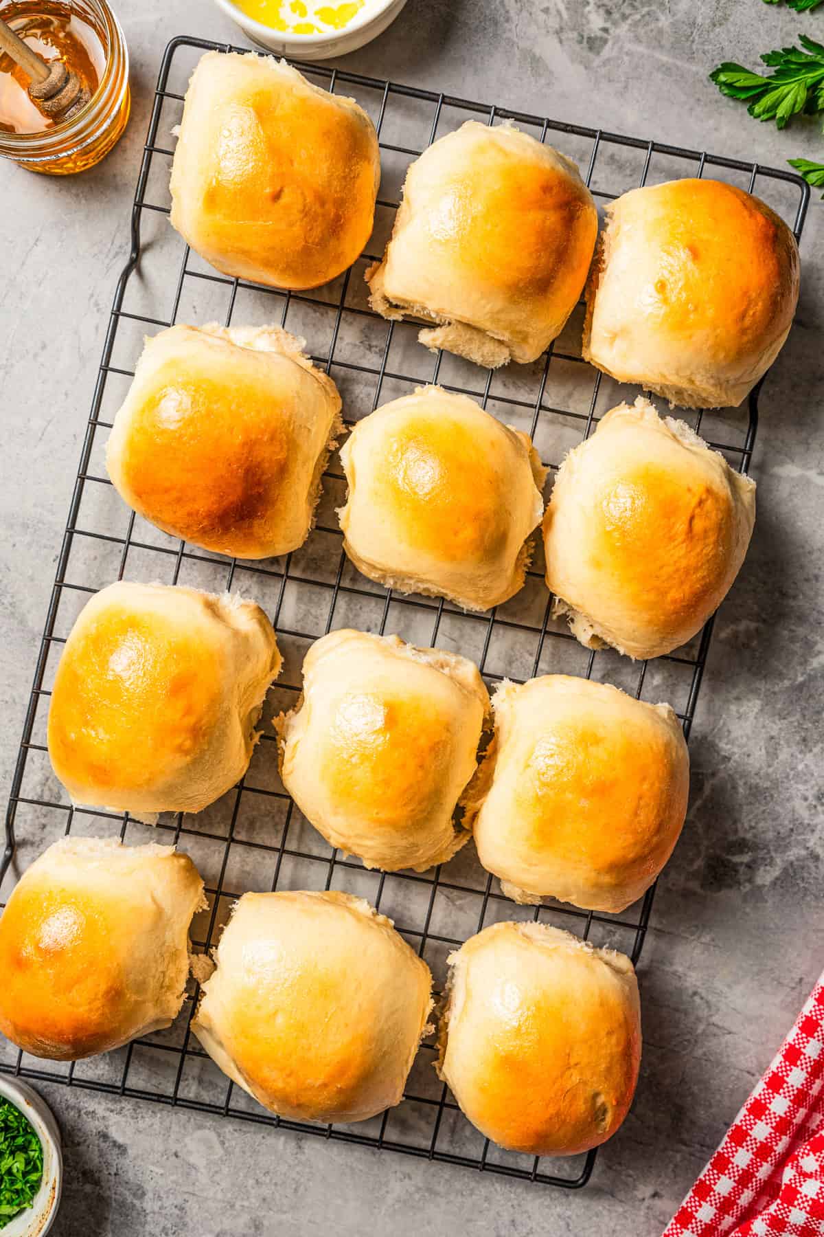 Overhead view of freshly baked dinner rolls cooling on a wire rack.