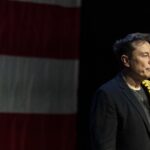 Elon Musk at a Trump rally in Pennsyvlania, holding a shirt over his shoulder.