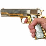 A person holding a golden gun