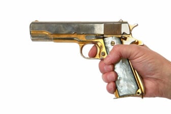 A person holding a golden gun