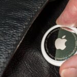 A photo of a person holding an Apple Air Tag