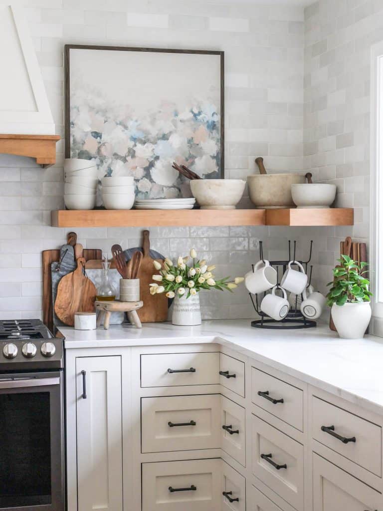 Open shelving in a kitchen with tile backsplash.